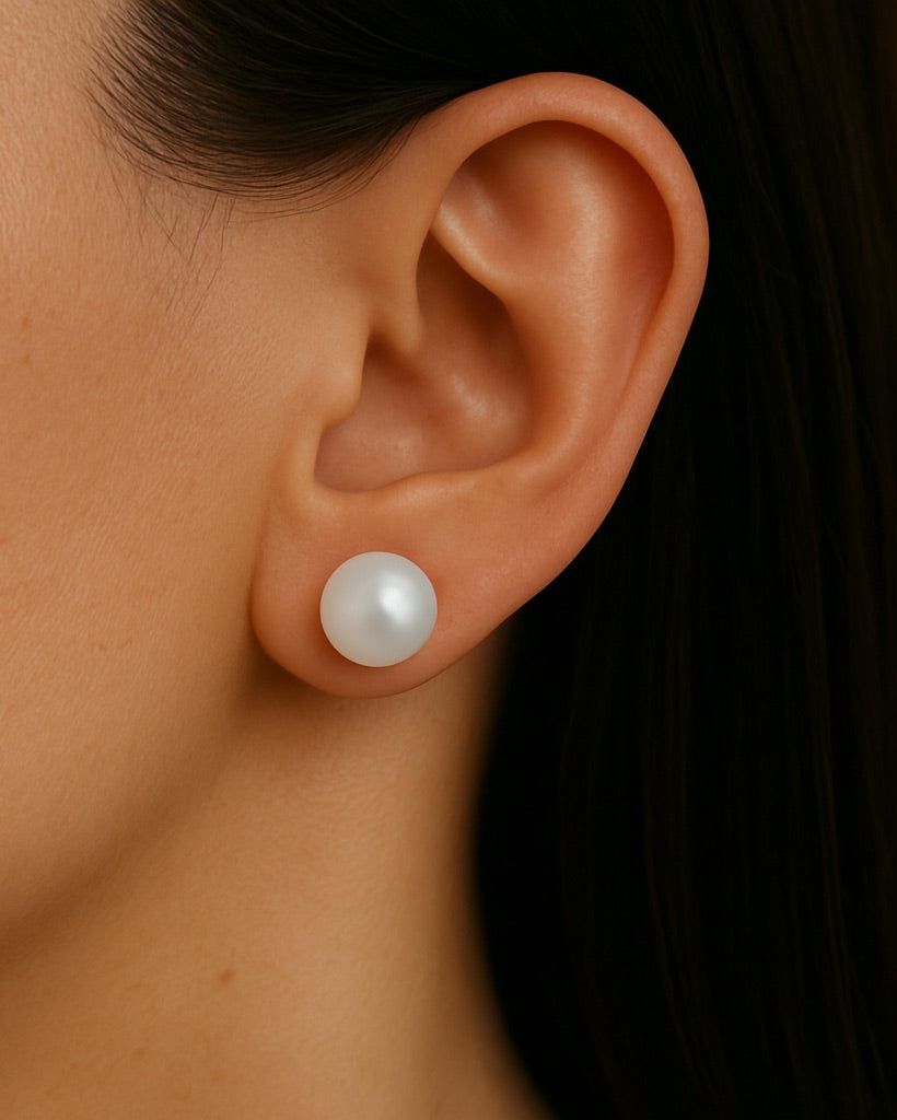 Natural 8–9mm pearl stud earrings worn on a woman's earlobe