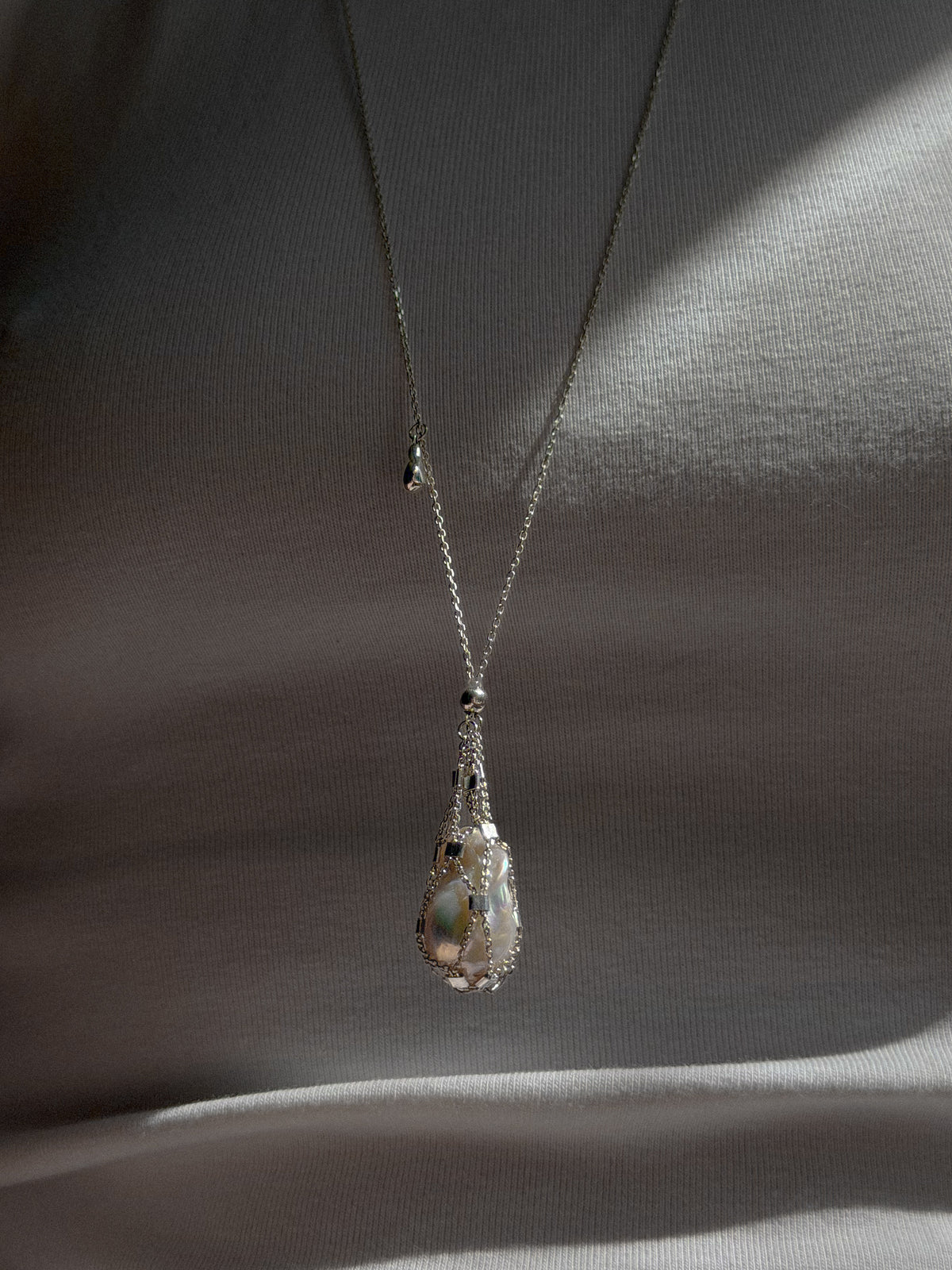 Sterling silver Hidden Pearl pendant with a natural baroque pearl inside an openable mesh