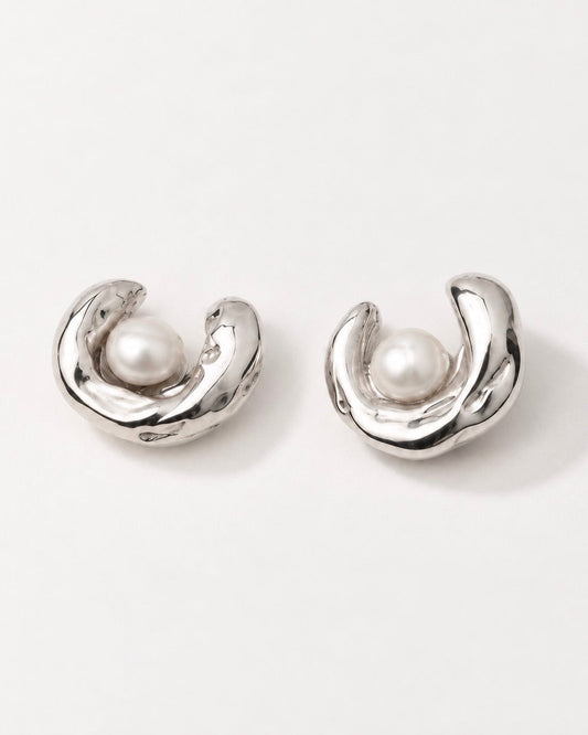 sculptural silver pearl stud earrings on model ear close up