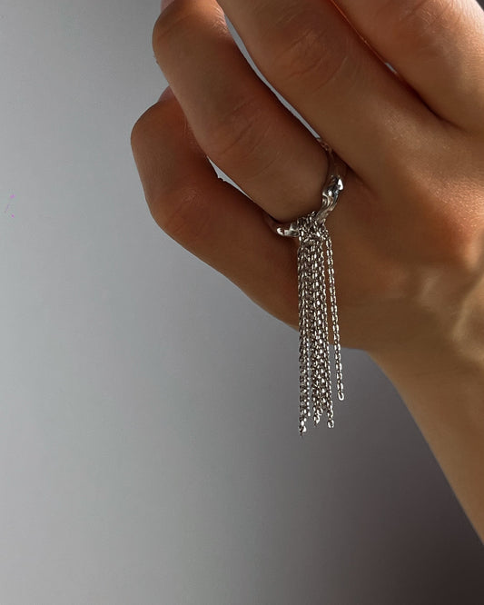 sculptural silver ring with moving chains close up hand