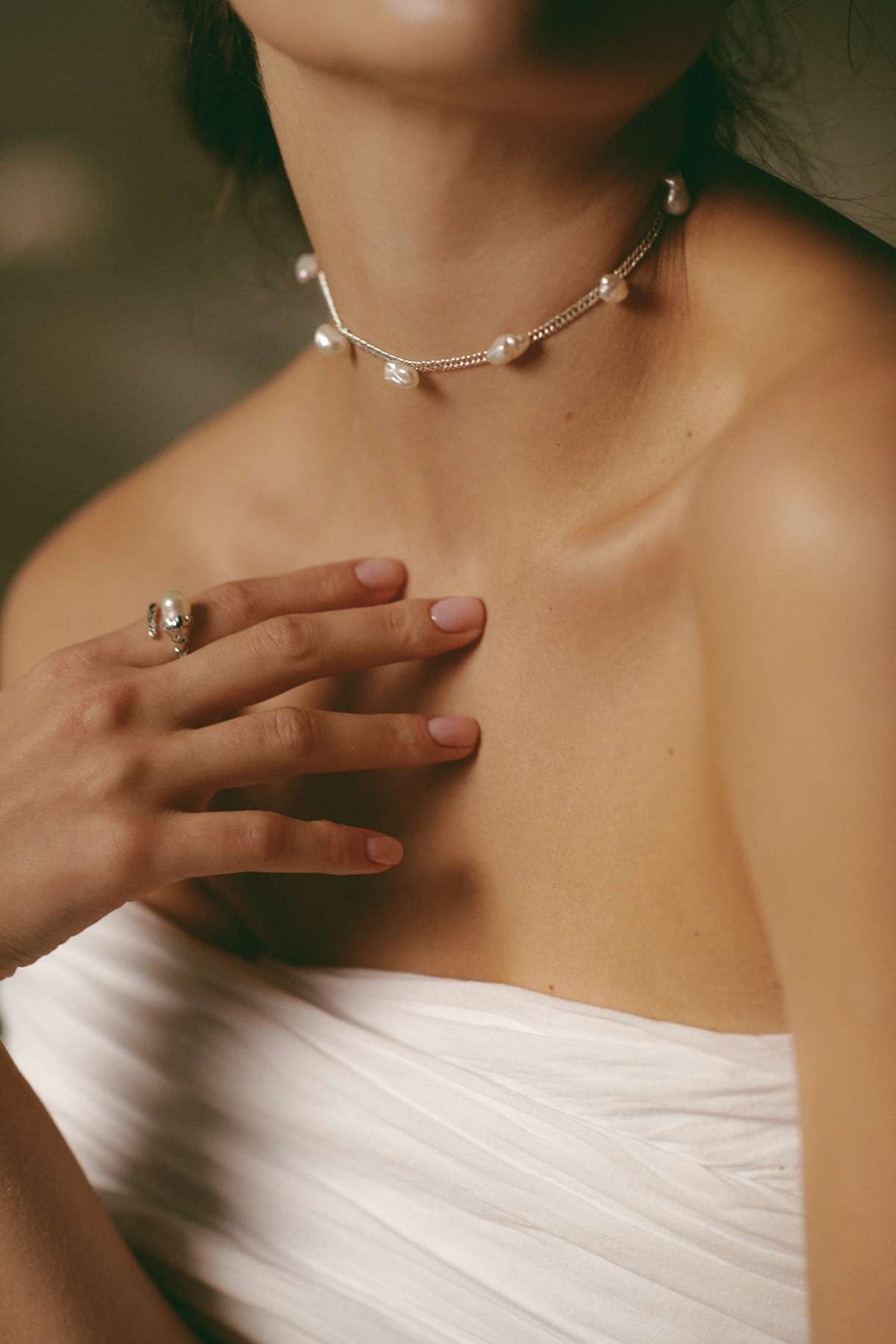 Sculptural silver setting embracing the natural baroque pearl on the Veil ring