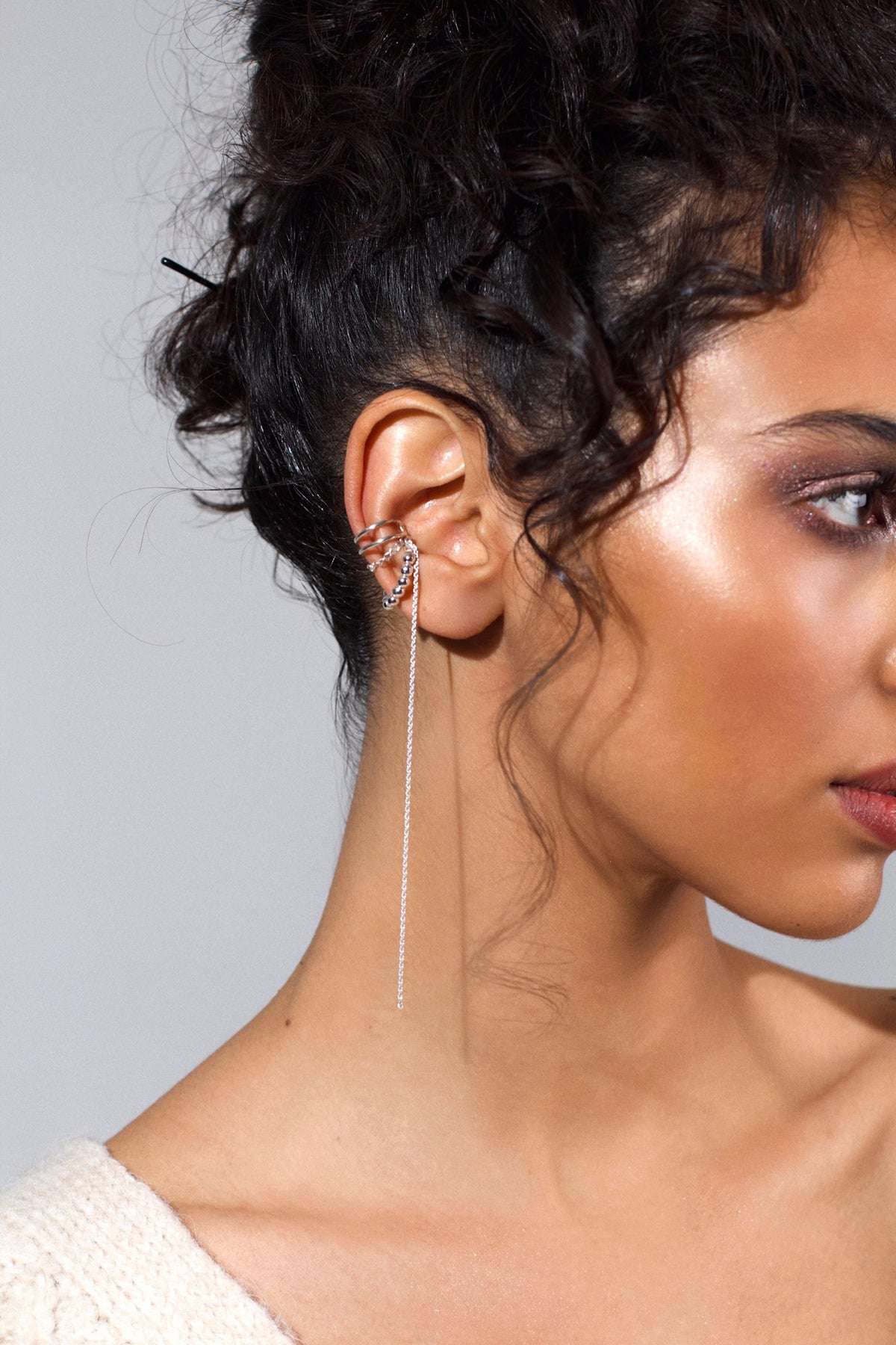Miley sterling silver chain ear cuff with a long dangling chain and silver sphere details, worn on a model