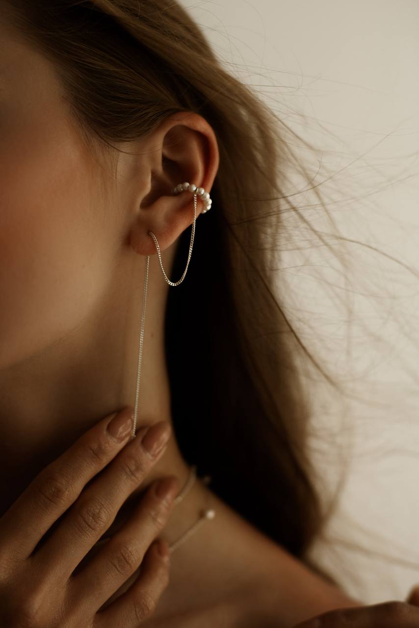 Freshwater pearl ear cuff with a long silver chain styled on the ear