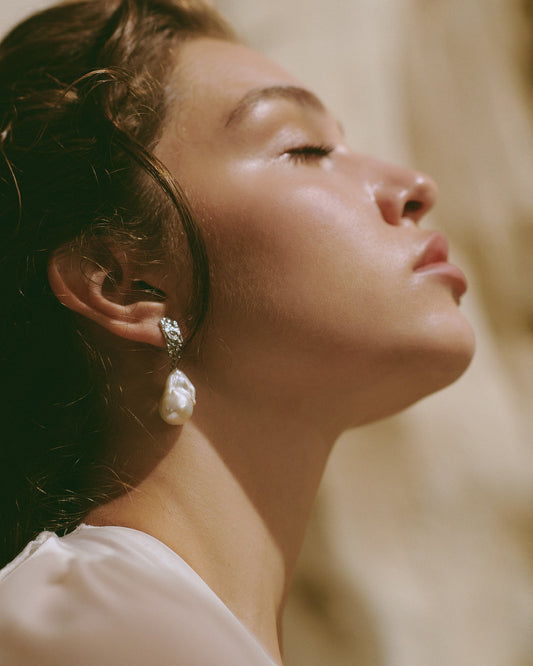 Model wearing MEDINA statement pearl earrings with textured sterling silver studs