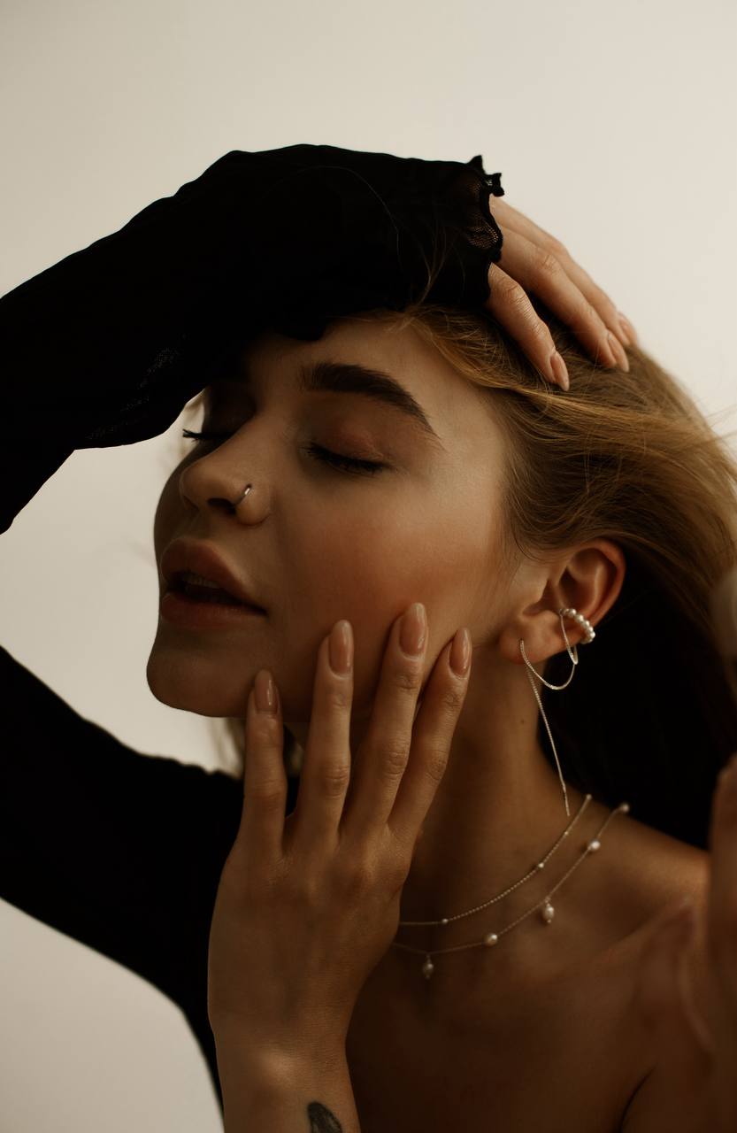 Pearl ear cuff with the chain threaded through a pierced earlobe