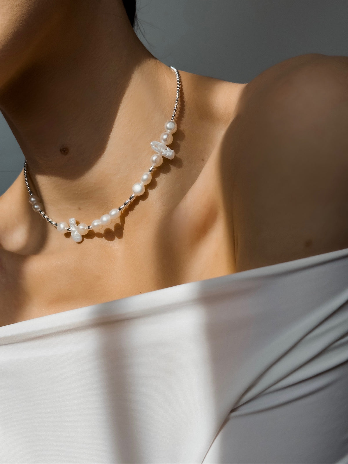 Morse Code pearl necklace worn around the neck