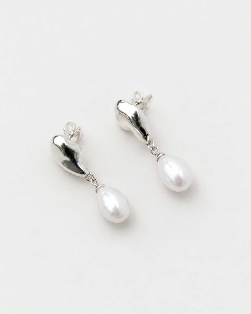 DEW sculptural pearl drop earrings with polished sterling silver forms and natural white pearls
