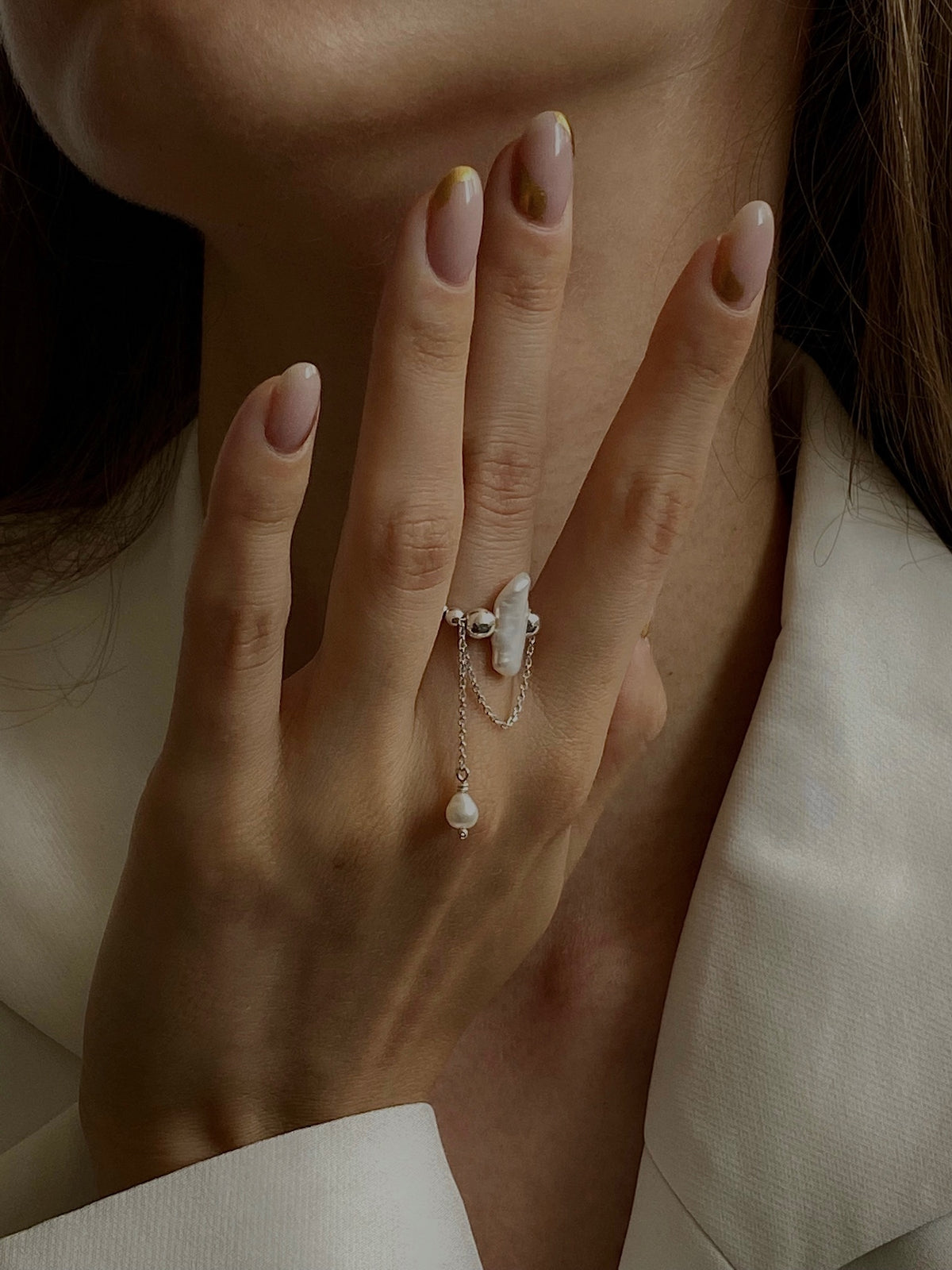 Kasei sterling silver pearl ring with delicate chains worn on a hand
