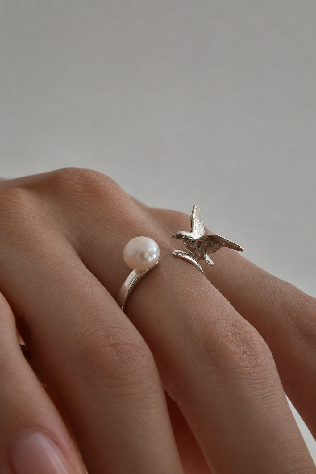 AILES Perle pearl bird ring worn on the finger, showcasing the natural pearl above the sculpted bird detail
