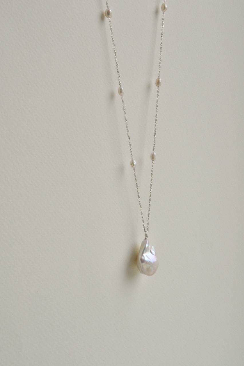 Close-up of the baroque pearl pendant on a long sterling silver necklace