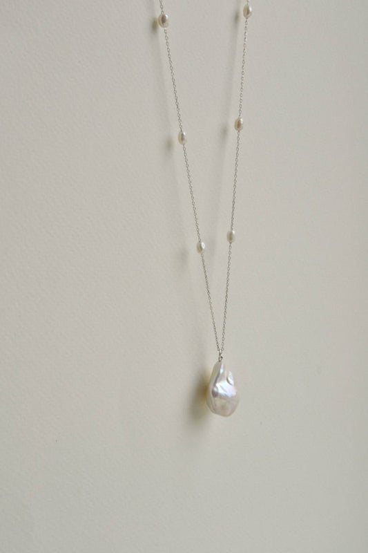 Close-up of the baroque pearl pendant on a long sterling silver necklace