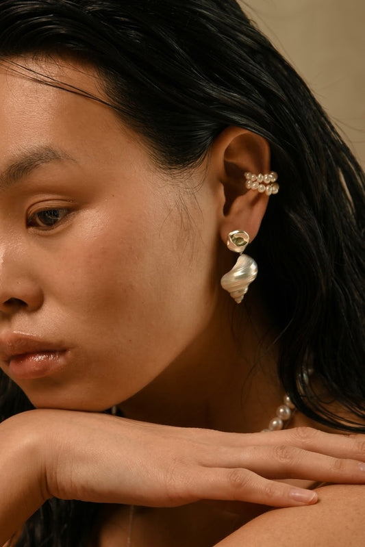 SirenCore shell drop earrings with sculptural sterling silver studs worn by a model