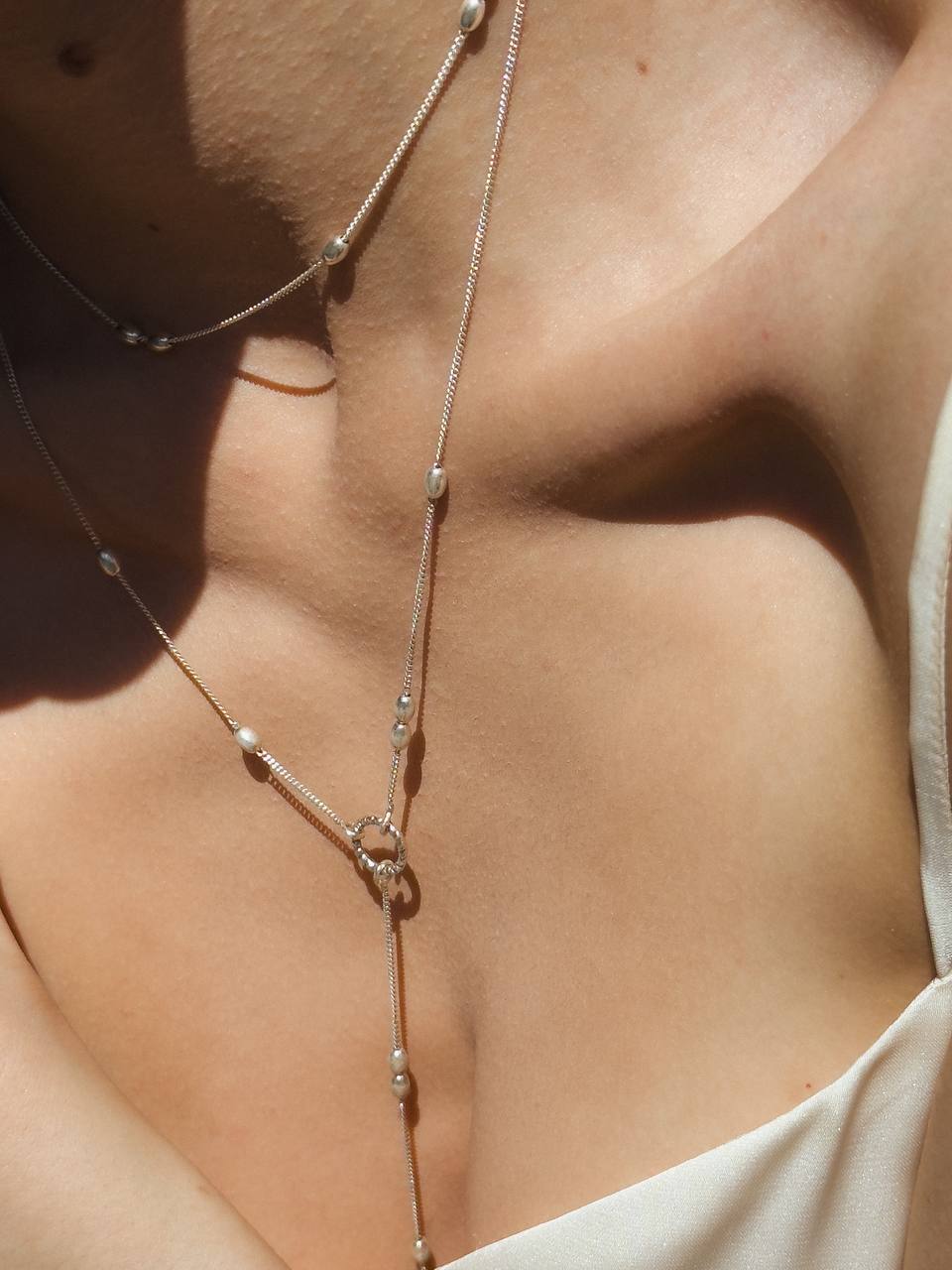 Close-up of the Olive choker showing its sculptural silver beads and chain

