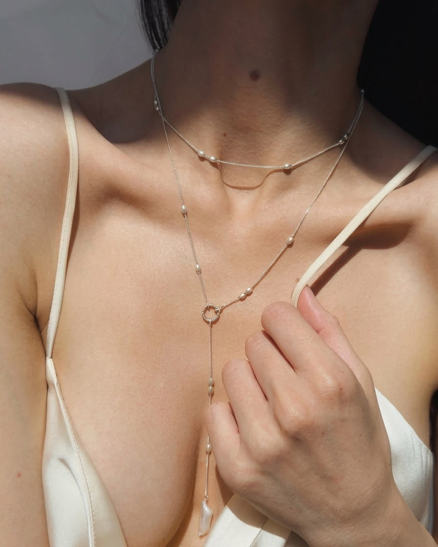 Olive silver bead choker worn around a woman's neck

