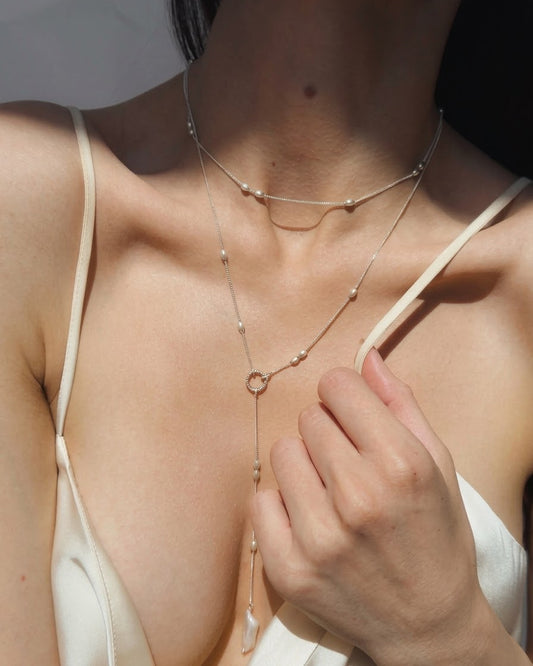 Olive silver bead choker worn around a woman's neck

