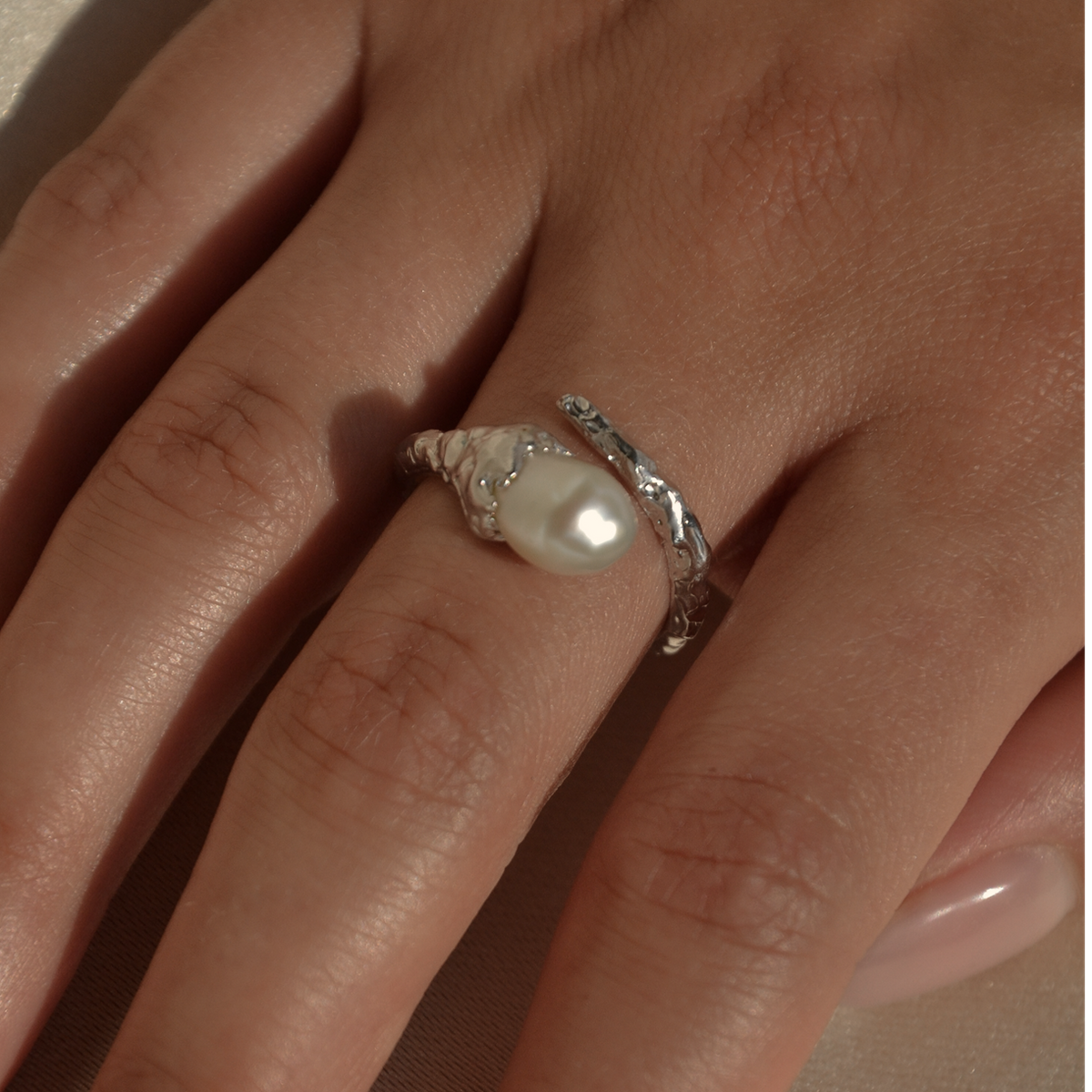 Veil sterling silver baroque pearl ring worn on a hand