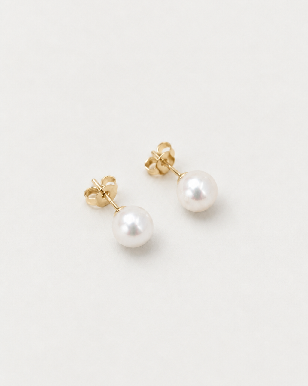 Close-up of natural 6mm pearl stud earrings with a 24K gold-plated finish