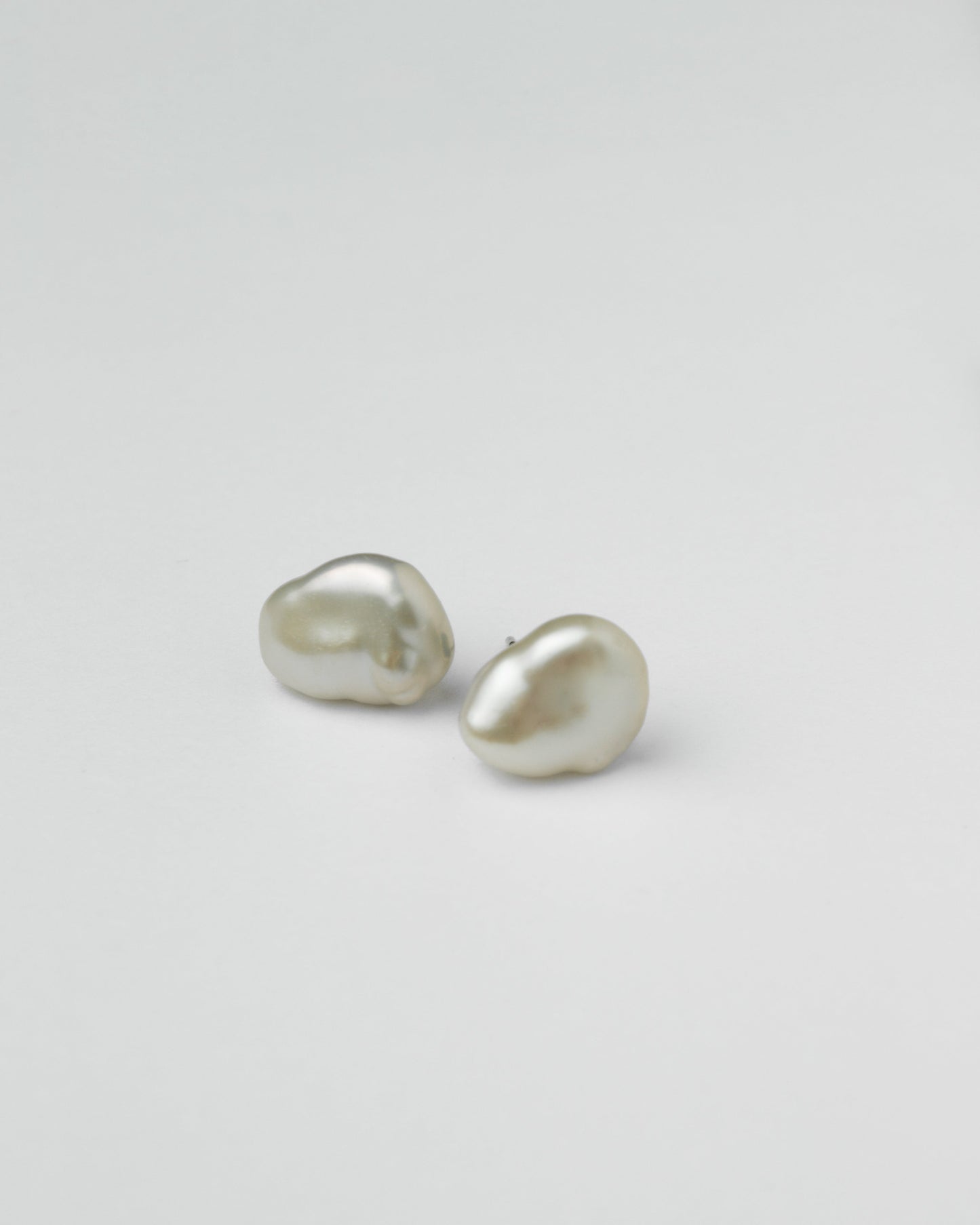 irregular pearl stud earrings on white background minimalist jewelry