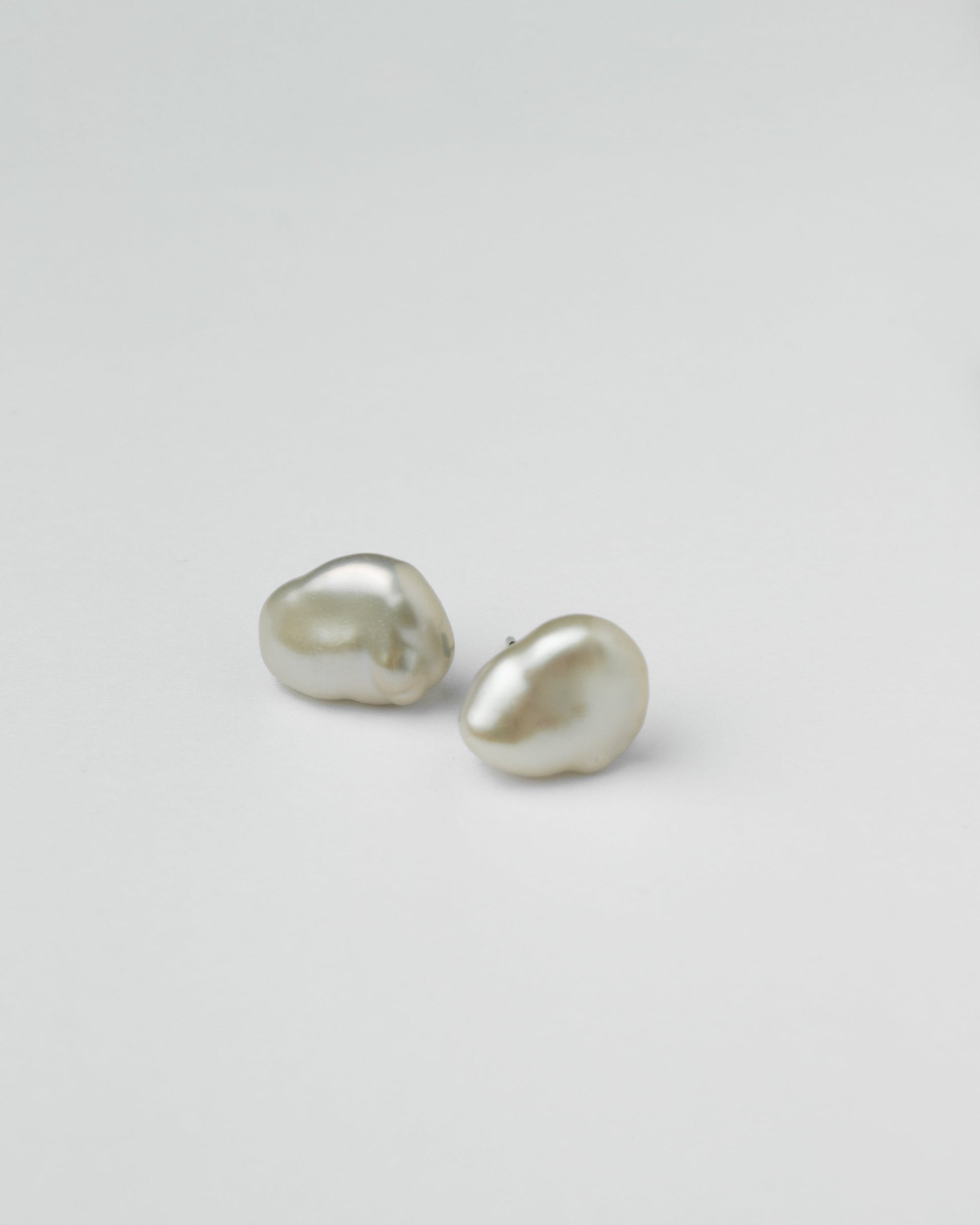 irregular pearl stud earrings on white background minimalist jewelry