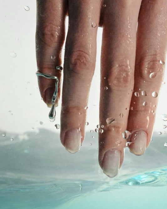 sculptural silver fingertip ring with hanging drop fluid design