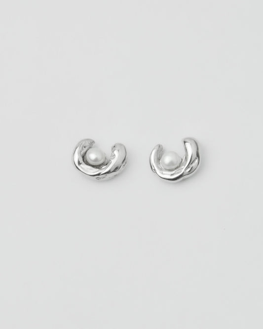 sculptural silver pearl stud earrings on model ear close up