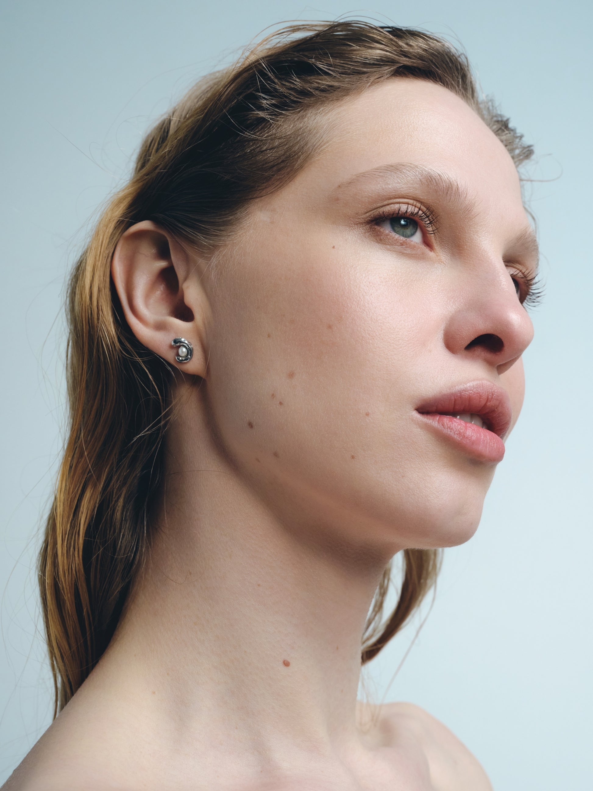 small silver stud earrings with pearl worn on ear minimalist jewelry